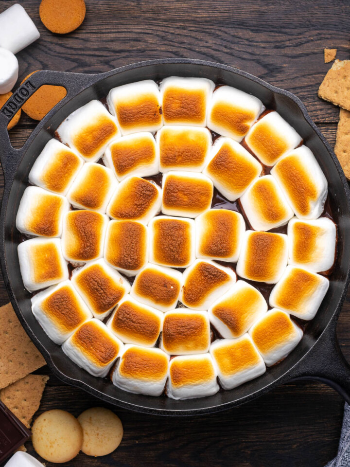 S'mores dip in a skillet with marshmallows on top toasted until golden brown.