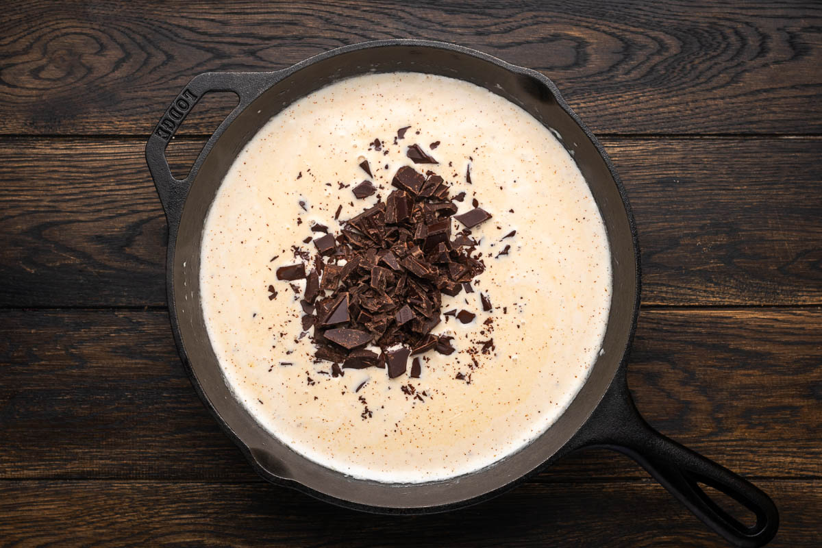 Chocolate is added to the skillet of cream.