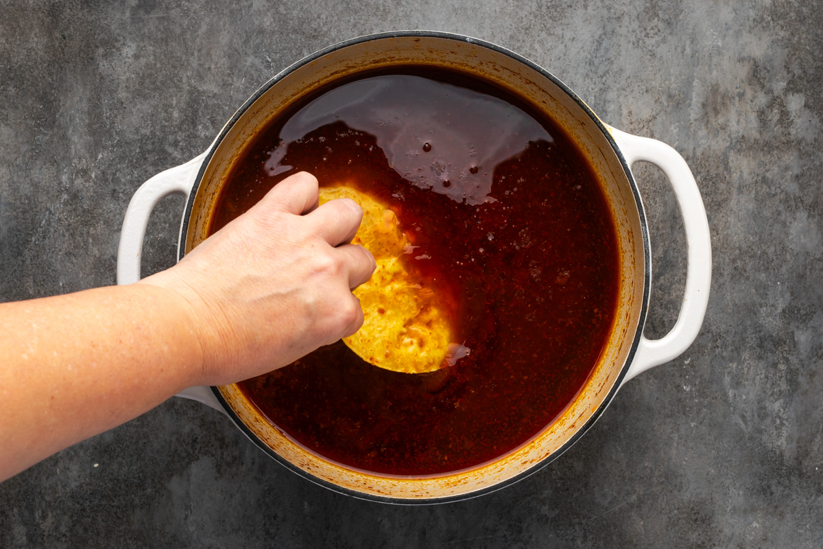 Tortilla dipping into juice. 