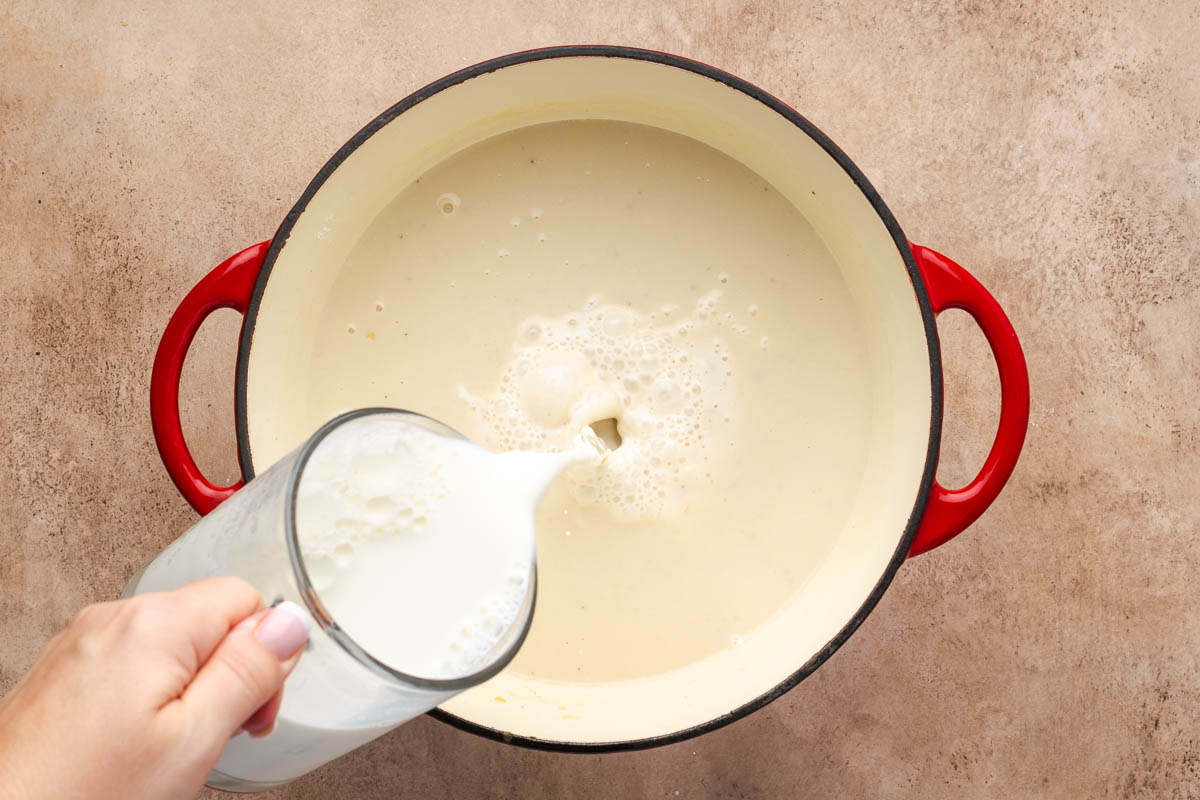 Milk being added to make the roux to thicken into a sauce.