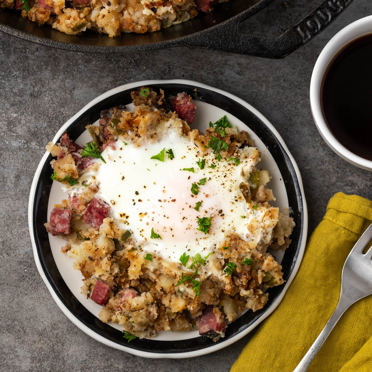 Pastrami hash on a plate with a fork to the side. 