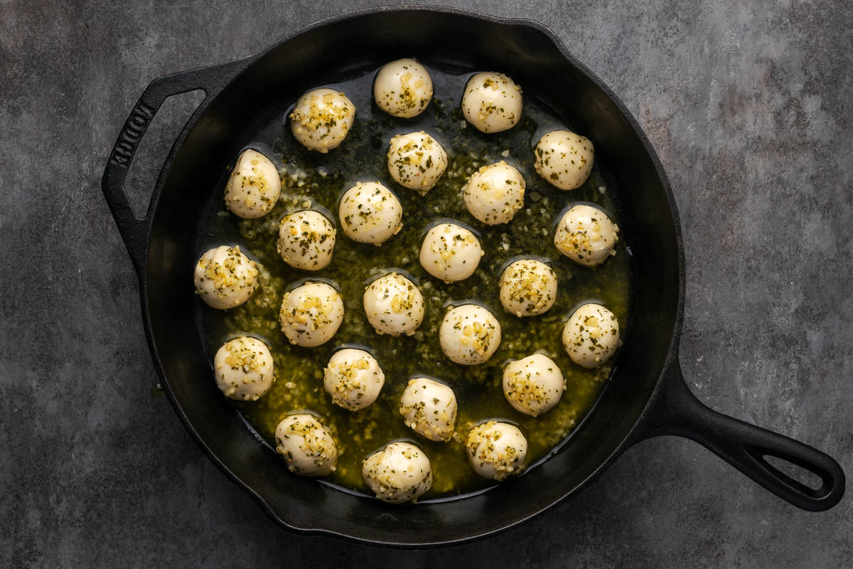 Each ball dipped into the garlic butter and placed in a skillet.
