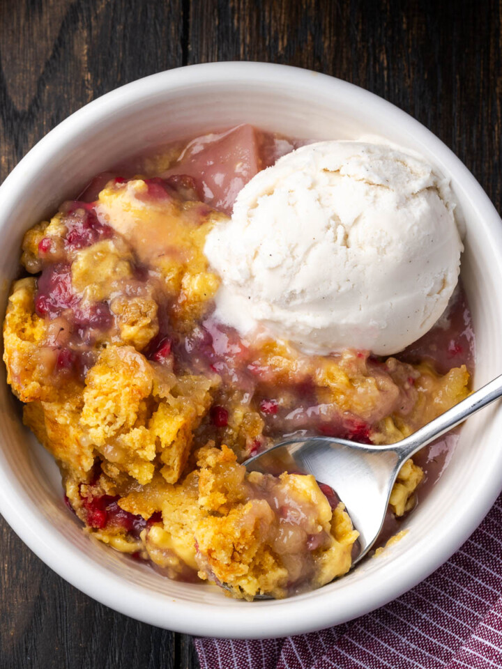 Easy pear raspberry dump cake with ice cream in a bowl.
