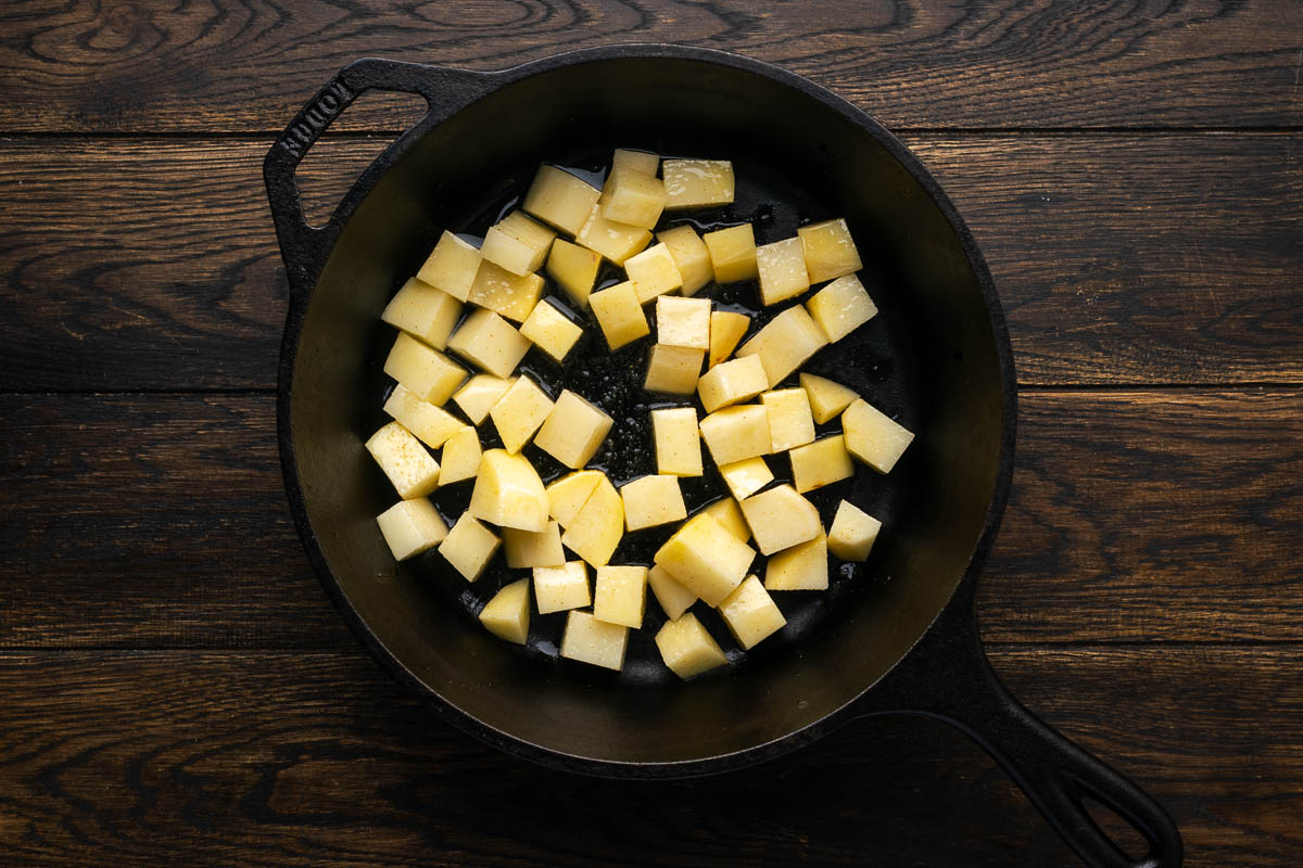 Potatoes added to a skillet.