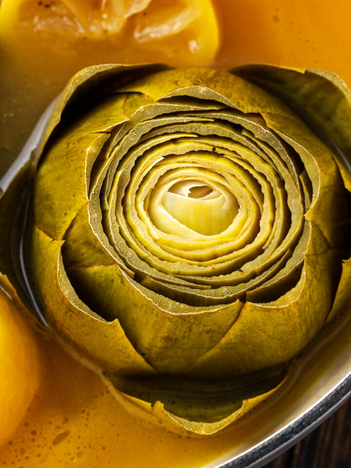 Steamed artichokes in a pot.