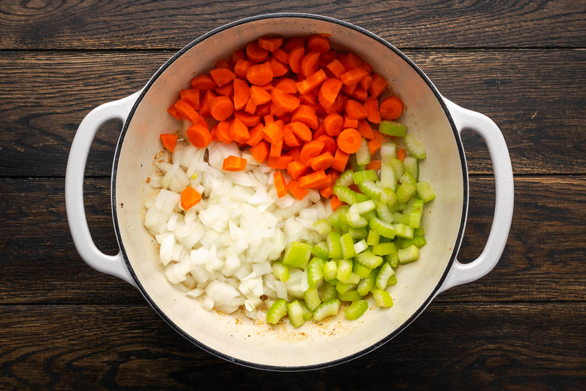 Siced onion, carrots, and celery sauteeing in a pan.