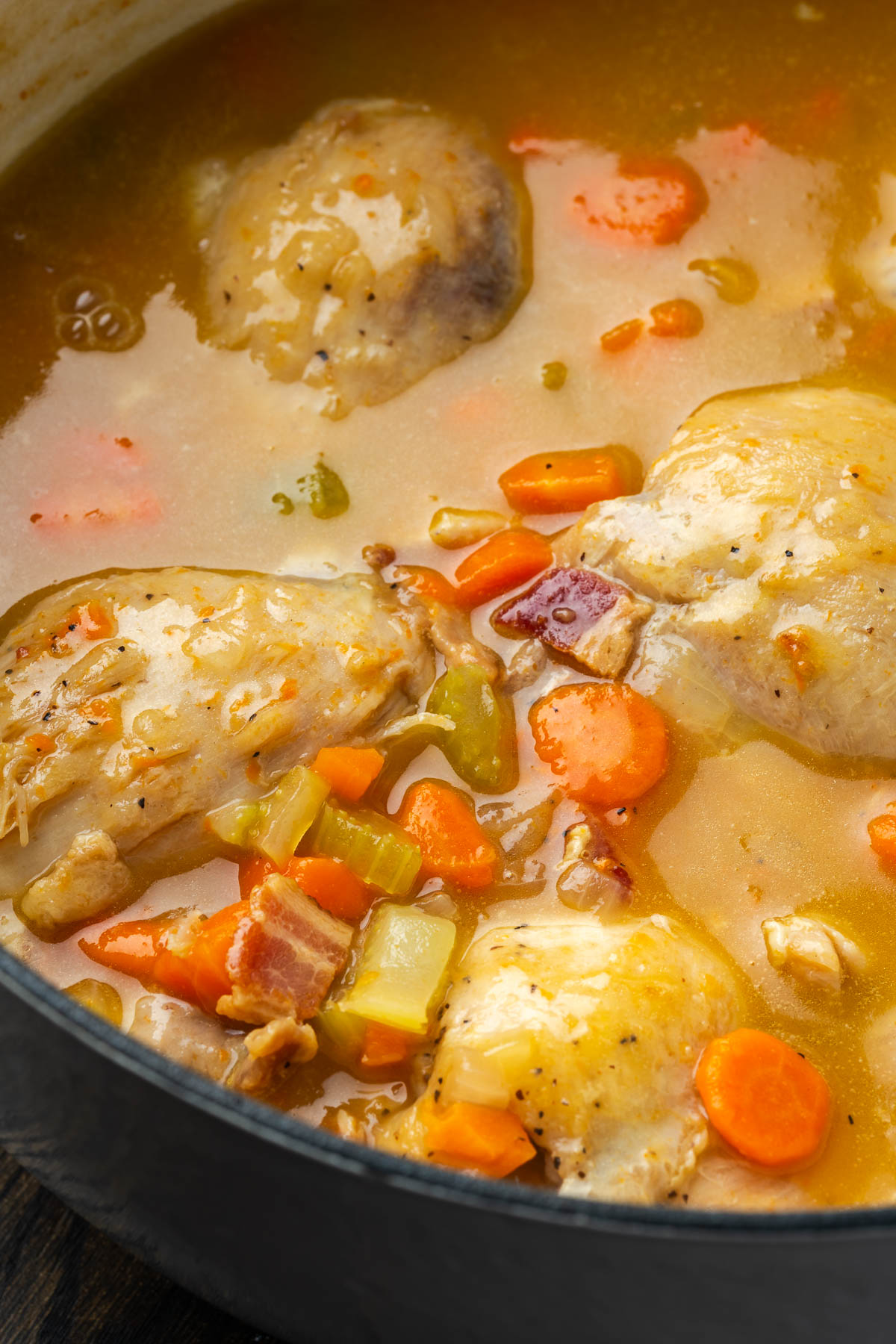 Chicken thighs in a sauce with celery, carrots, onions and bacon.