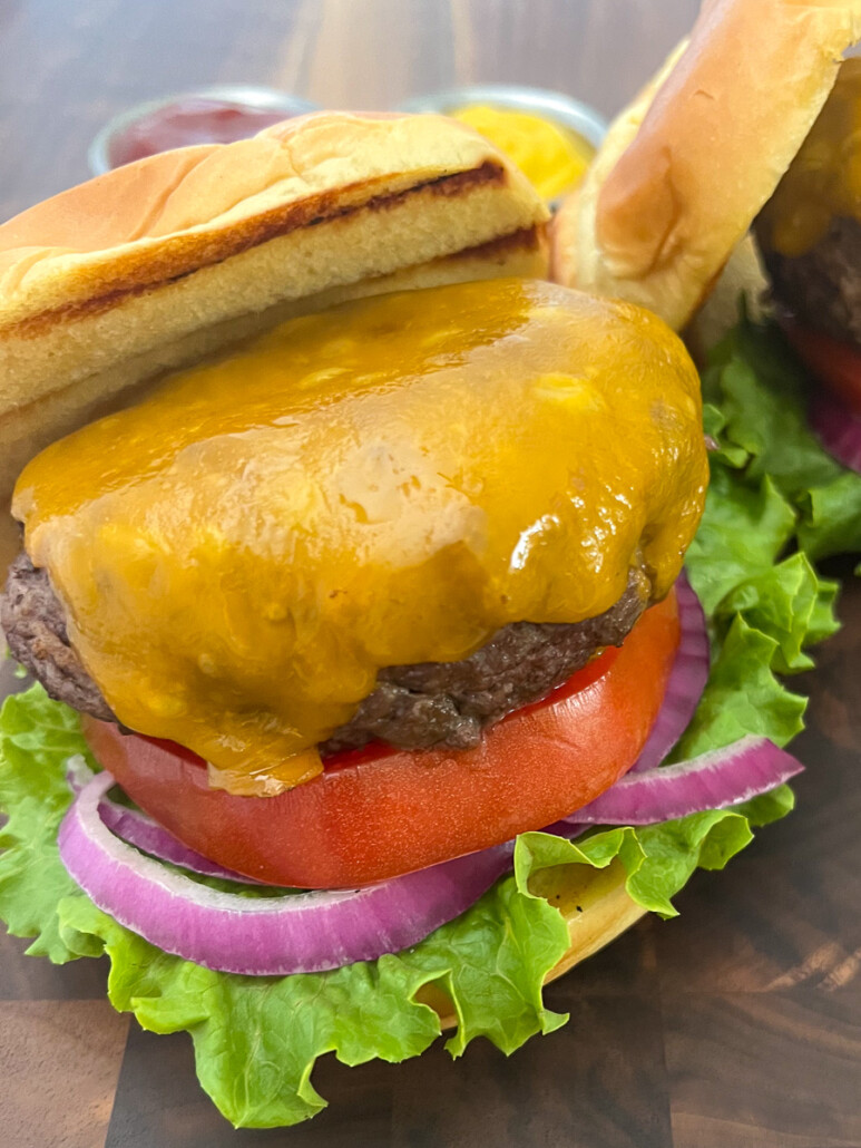Cast iron burger on a plate topped with cheese. 