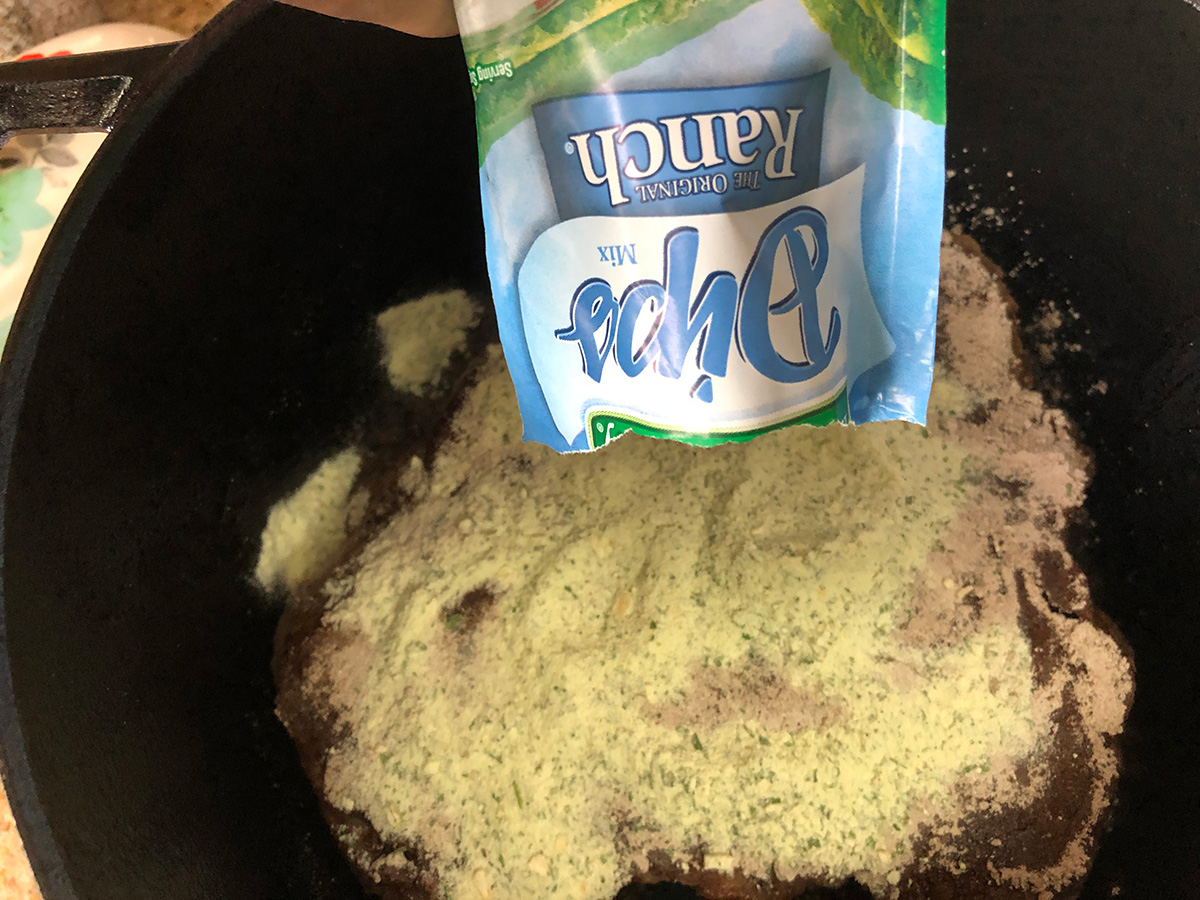 Adding the seasoning packets to the pot.