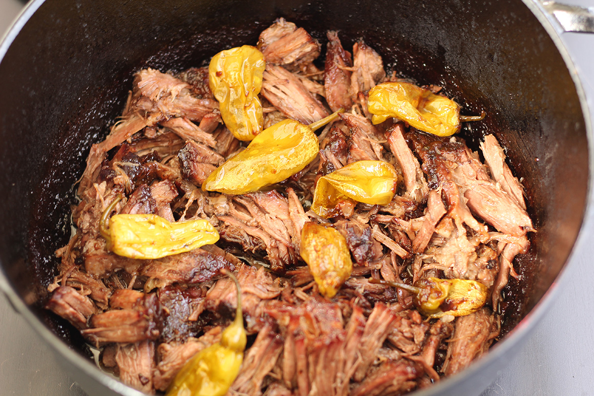 Dutch oven Mississippi pot roast shredded in a pot.