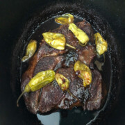 Mississippi pot roast in a Dutch oven with pepperoncinis.