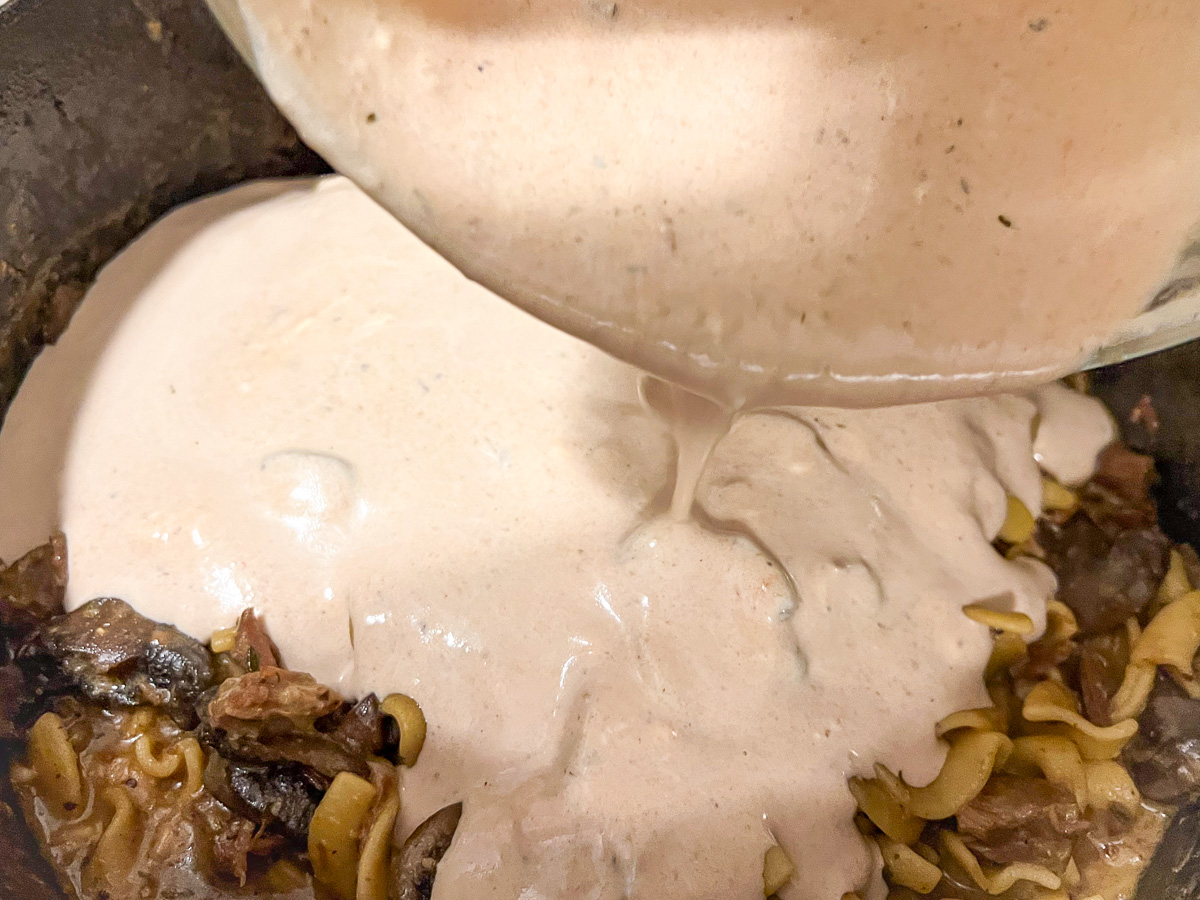 Adding the tempered sour cream into the pot.