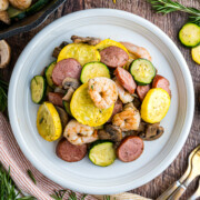 Shrimp, sausage, zucchini, squash on a plate.