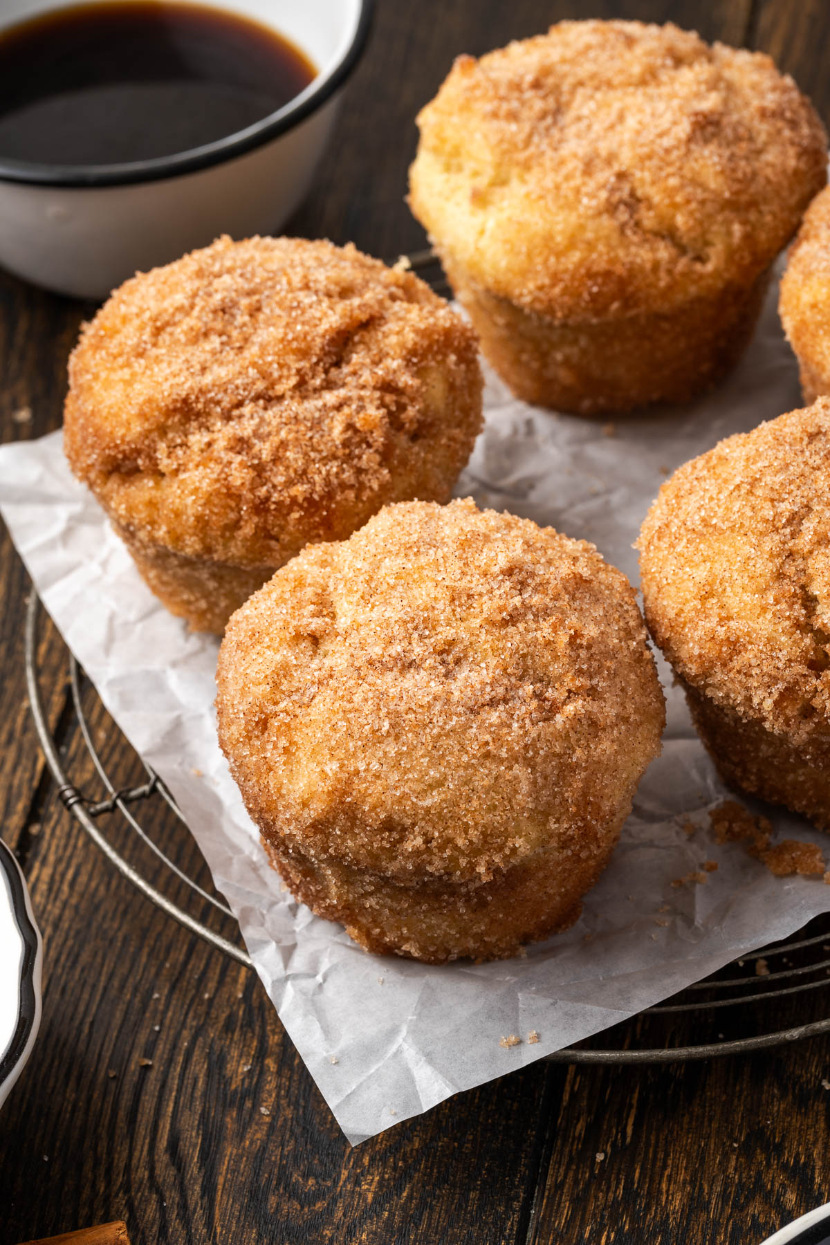 French breakfast puffs covered with cinnamon-sugar on parchment paper.