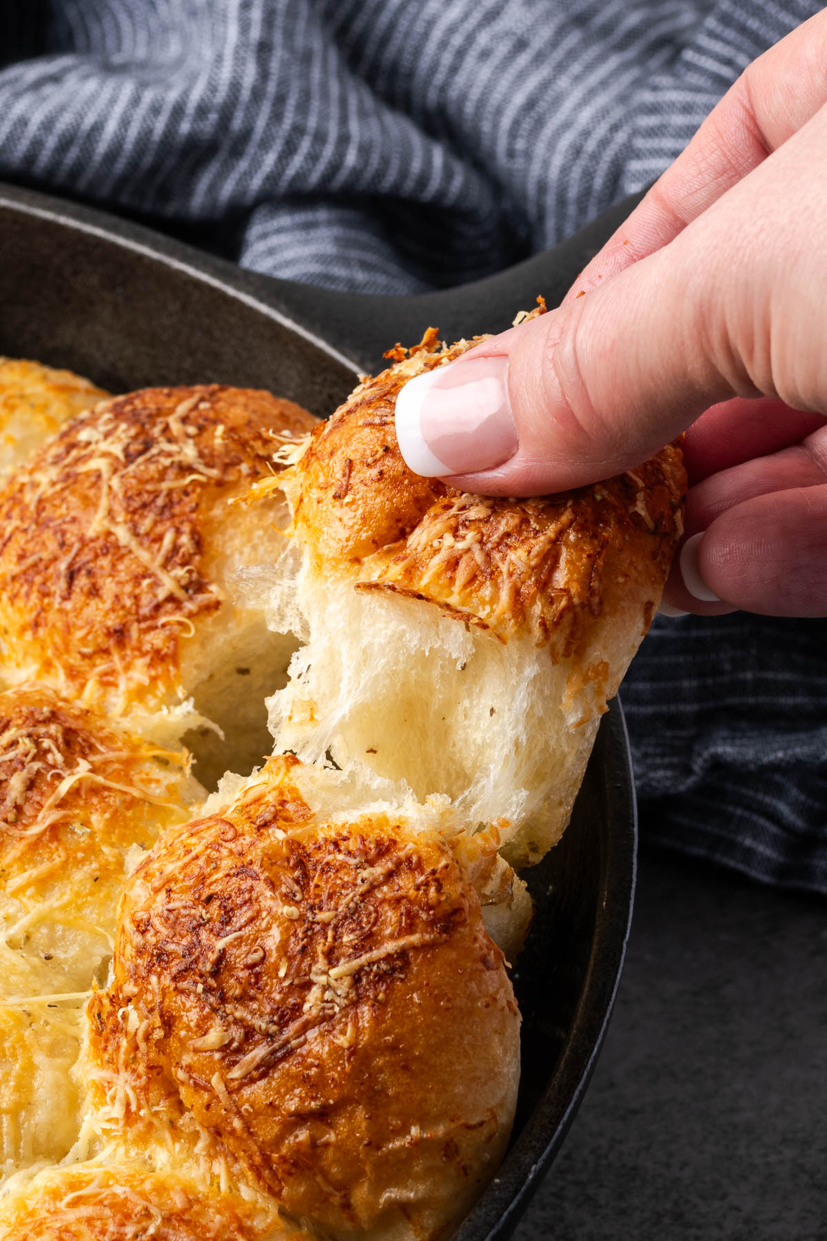 Garlic bread being pulled apart from the loaf.