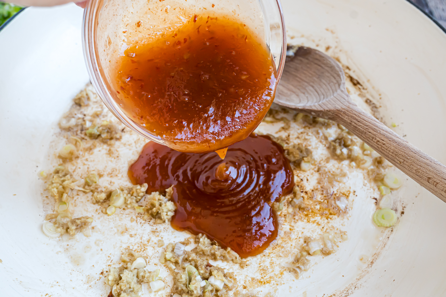 Garlic, ginger and the chili sauce added to the skillet.