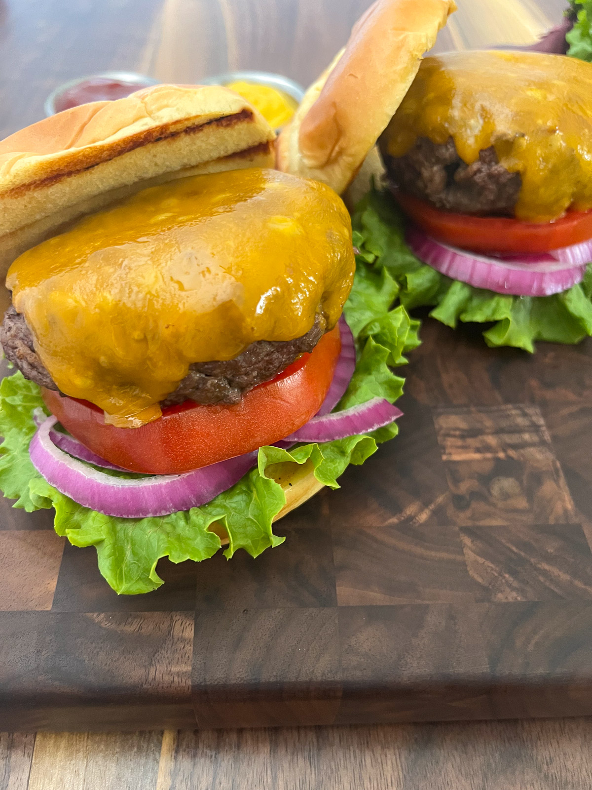 Cast iron burger on a plate topped with cheese.