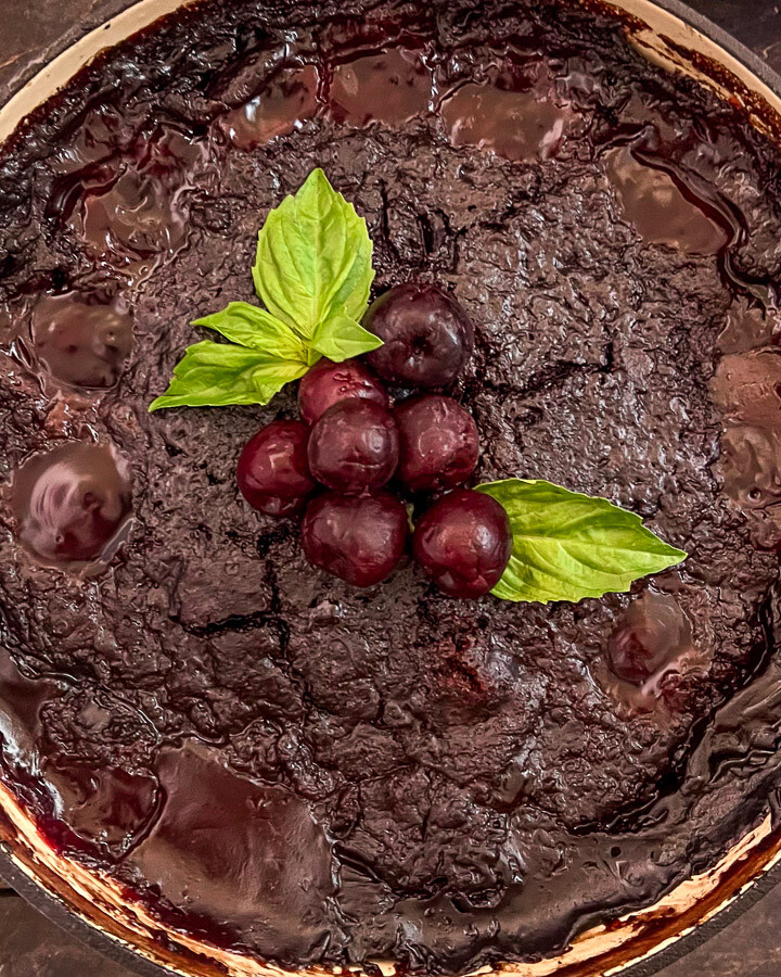 Cola Chocolate Cherry Dump Cake has cooled, garnished with fresh cherries and mint, and is ready to be served.