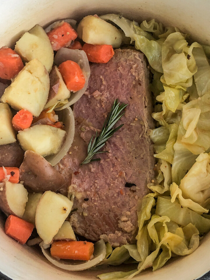 Dutch oven corned beef and cabbage with potatoes and carrots on the side.