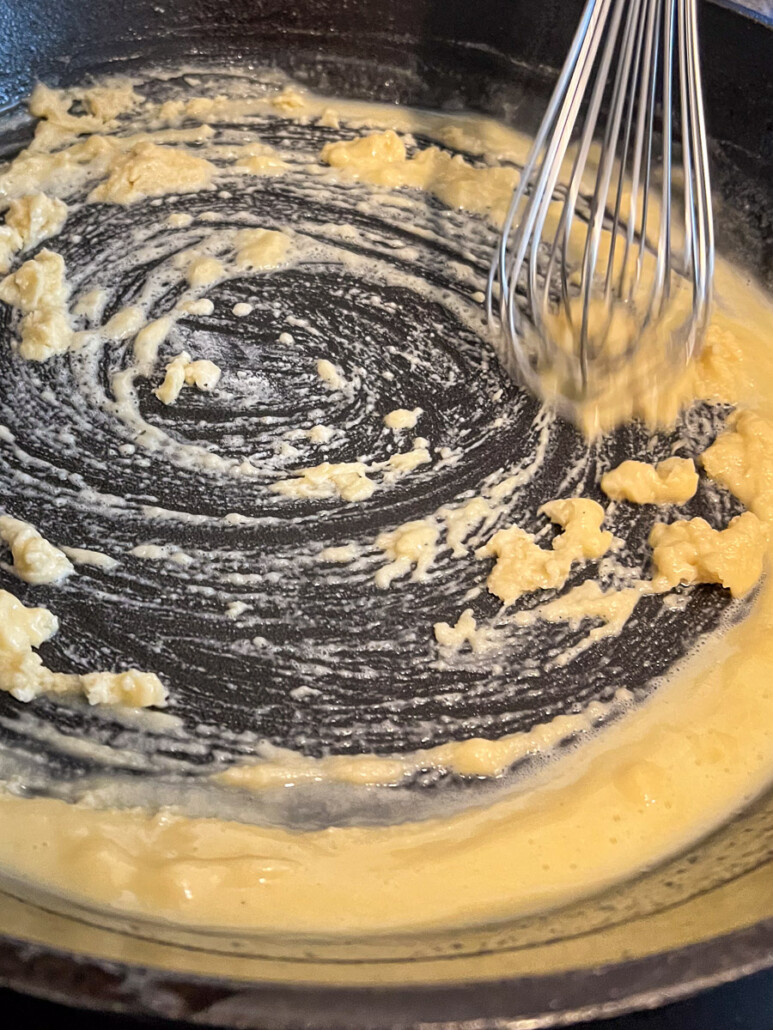 Flour being whisked into the butter to make a roux.