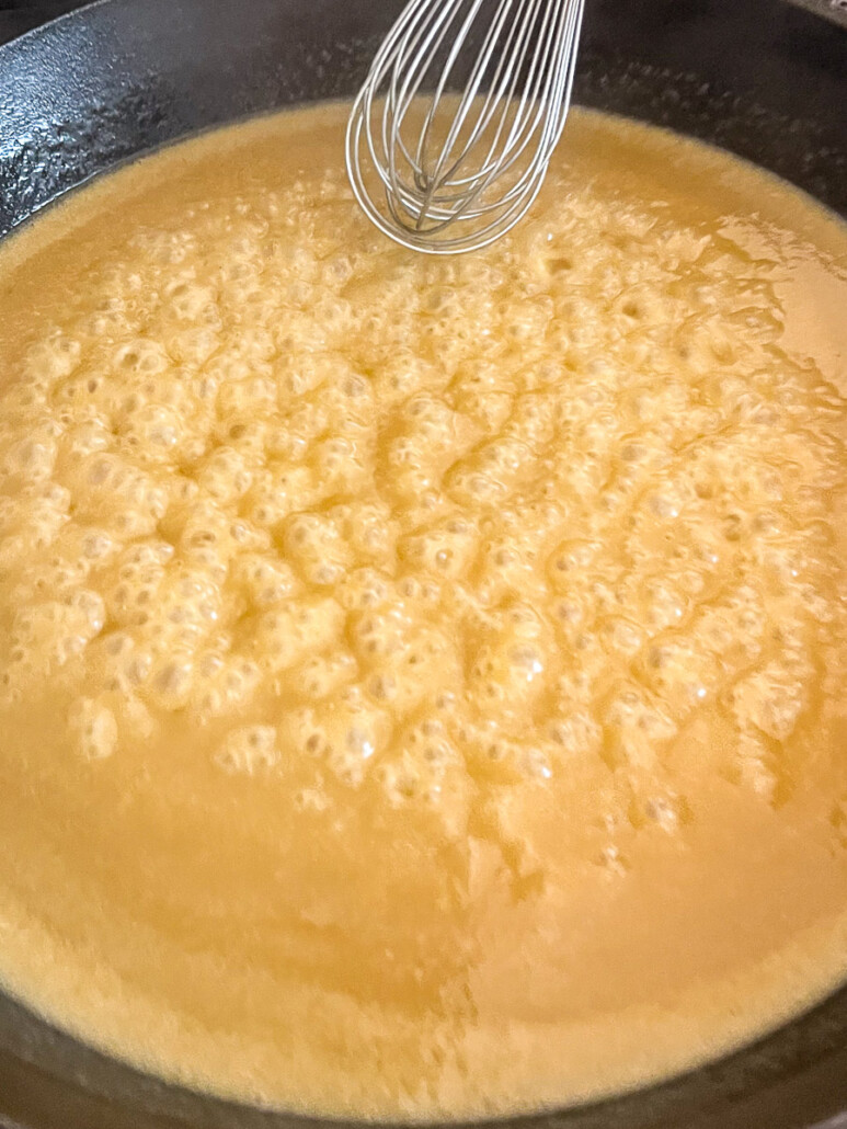 The gravy at a high simmer to thicken.
