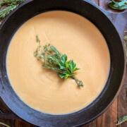 Turkey gravy cooked and garnished with a bouquet of fresh herbs in a cast iron skillet.