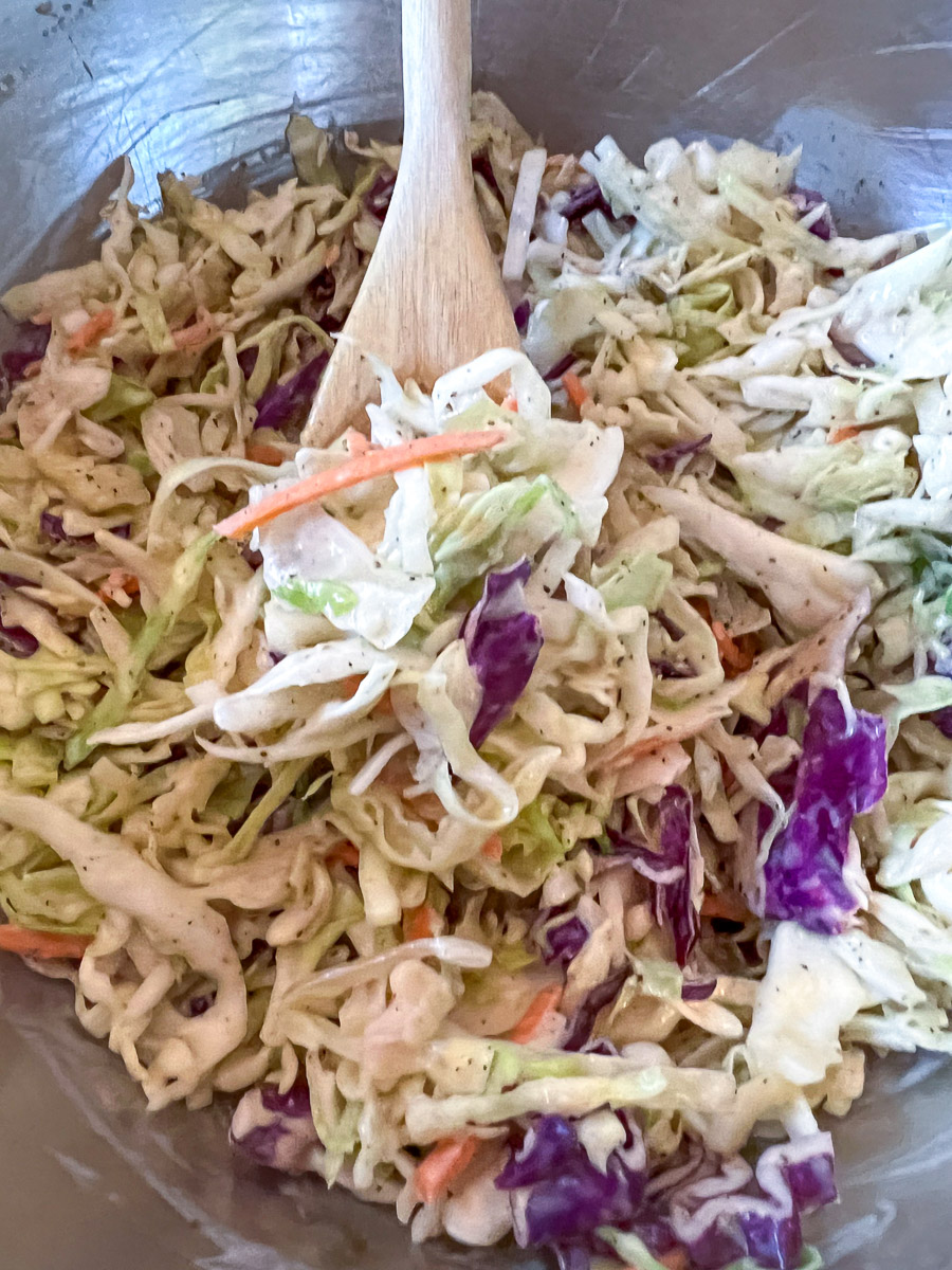 Simple coleslaw fully tossed and combined in a large bowl