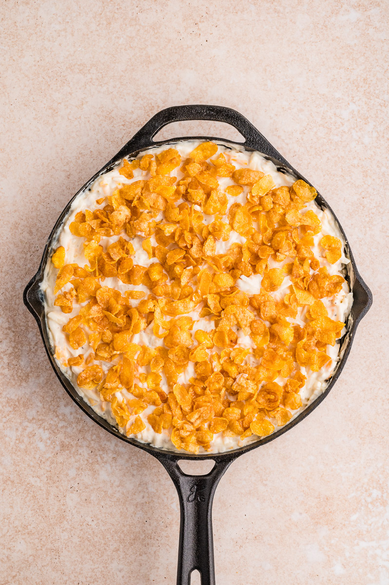 Dutch oven cheesy potatoes with cornflake mixture added on top.