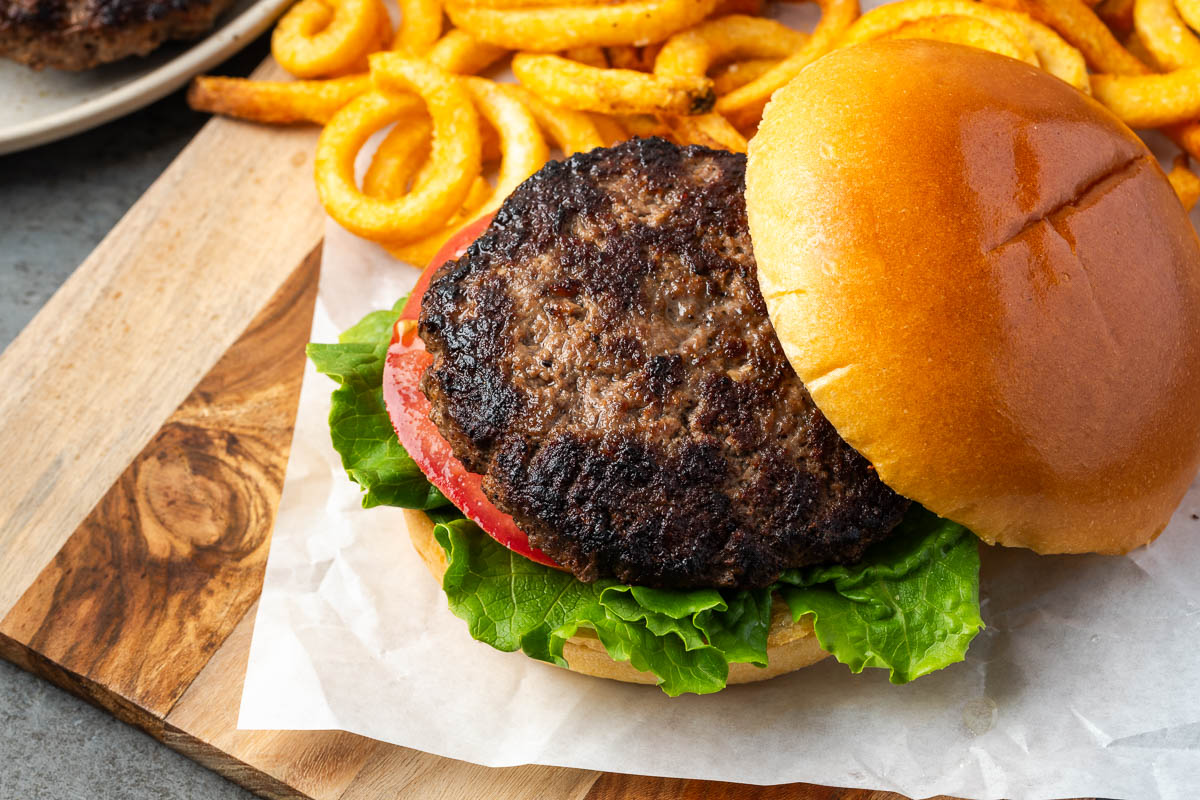 The bison burger put on a bun with toppings.