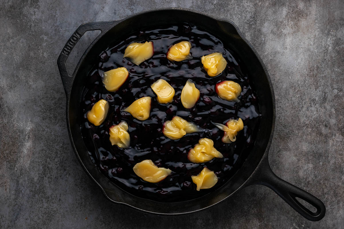 Blueberry added to a skillet with lemon curd on top.