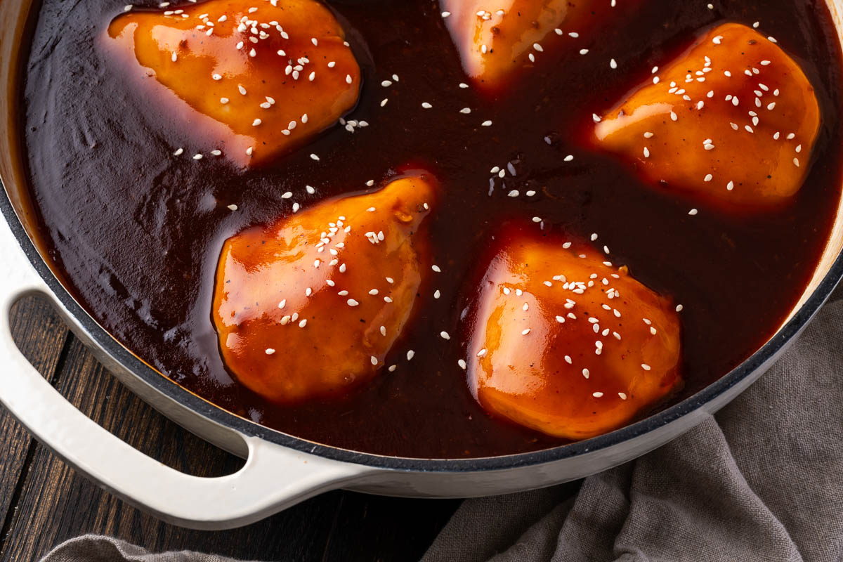 Chicken cooked and cooled to serve with sesame seeds on top.