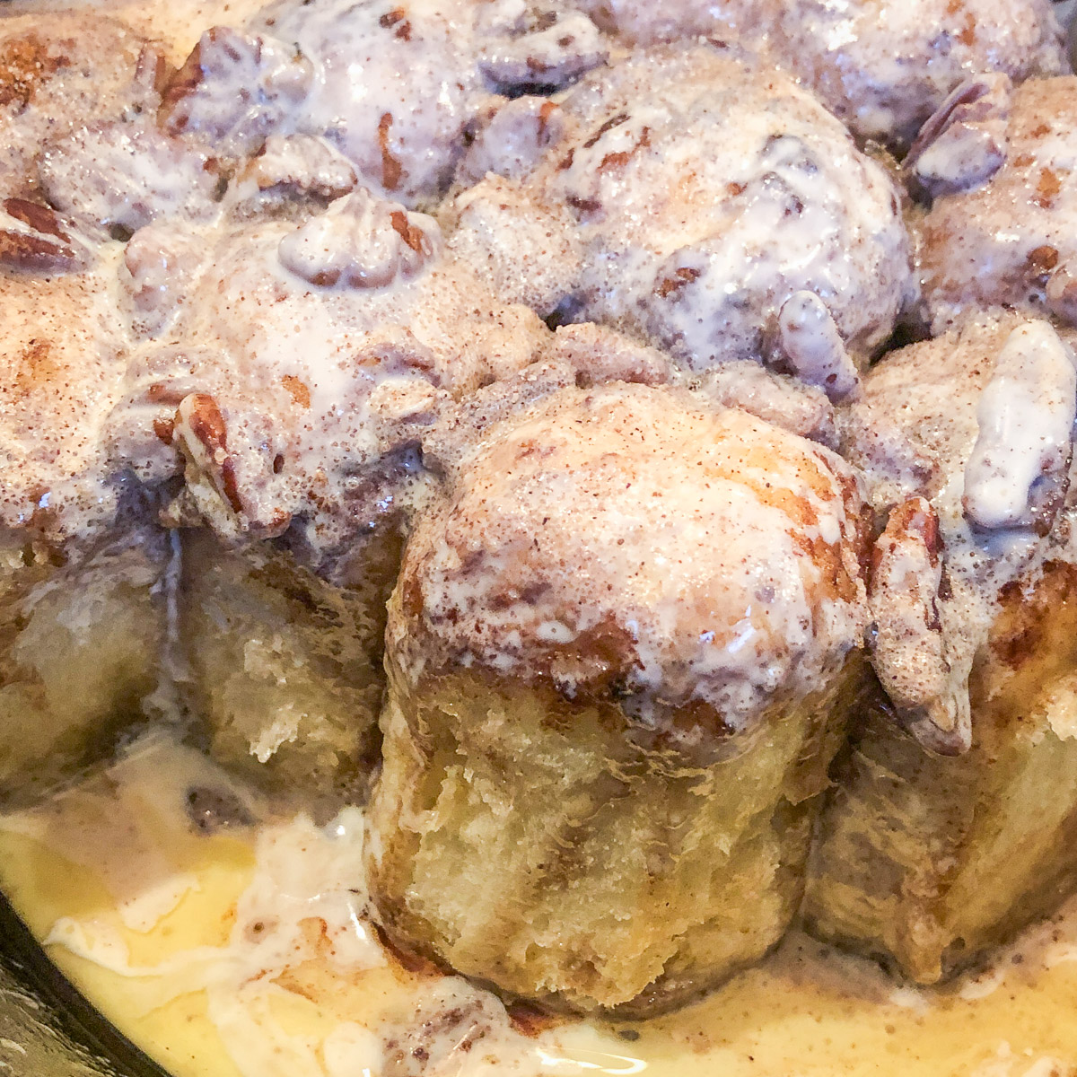 Dutch oven cinnamon rolls with a few pulled from the pan.