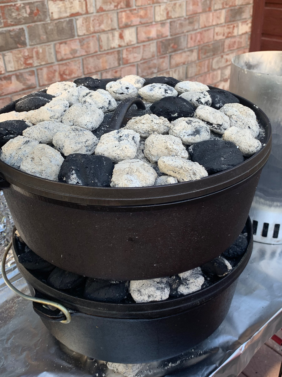 Dutch oven lasagna cooking over coals.