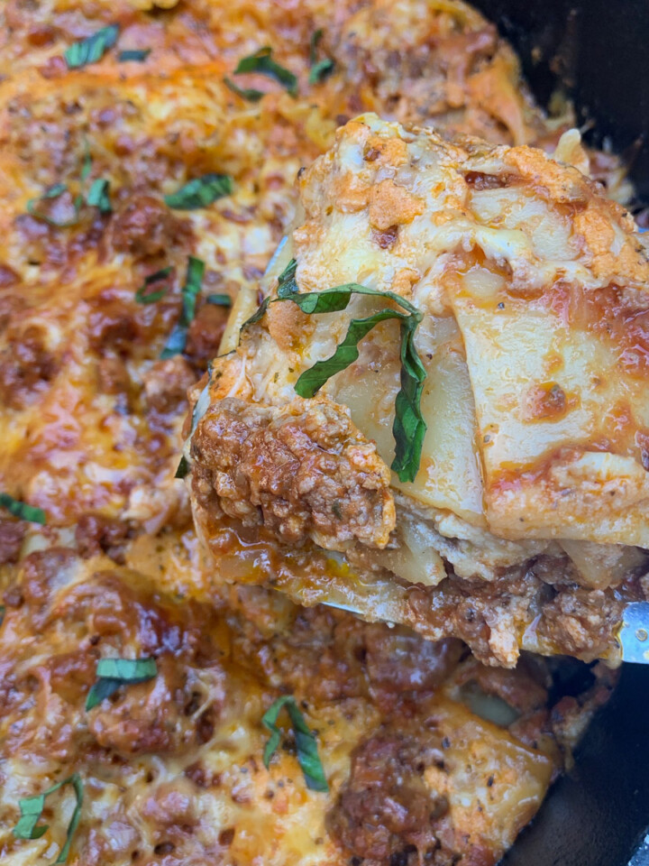 A spatula lifting up a piece of Dutch oven lasagna.