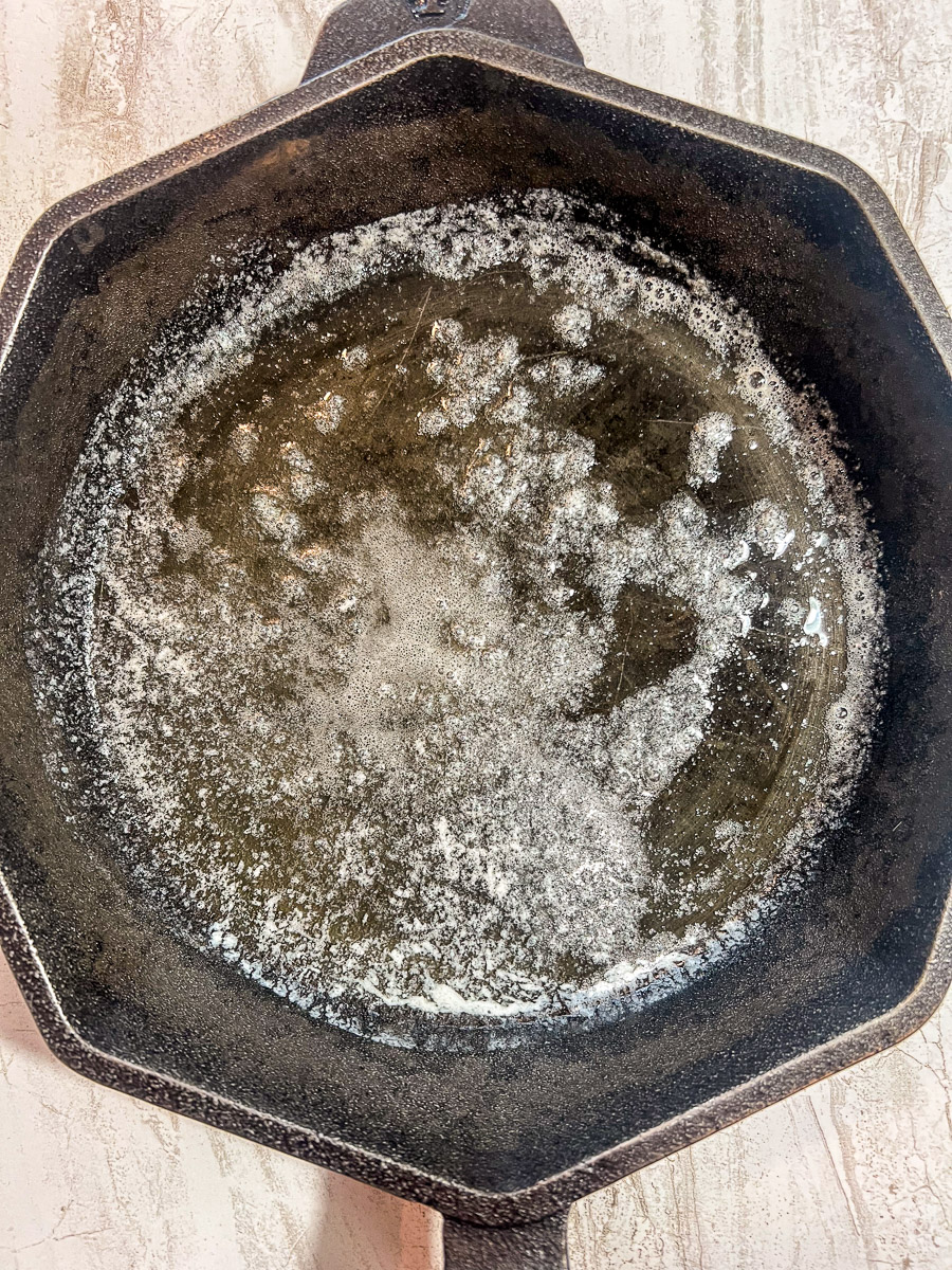 Butter melted in a cast iron skillet.
