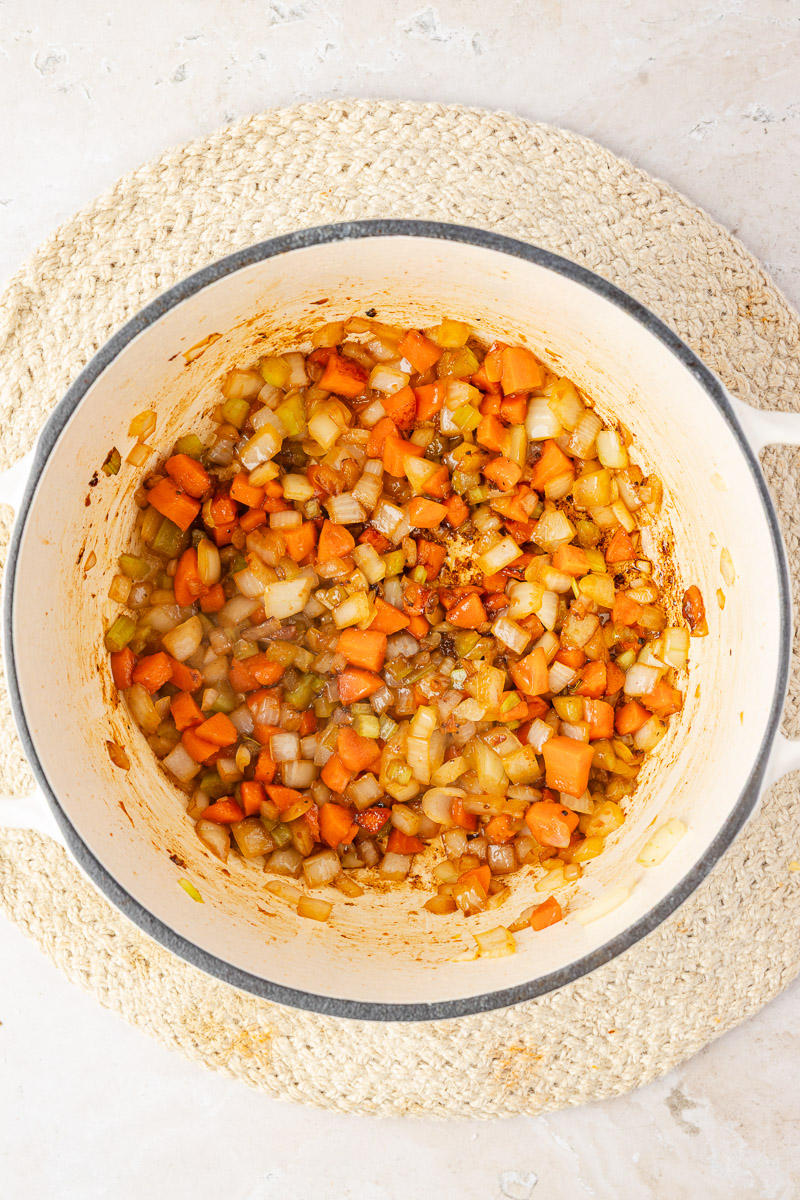 Onion, carrot, and celery cooking, then tomato paste and garlic added into the mixture.