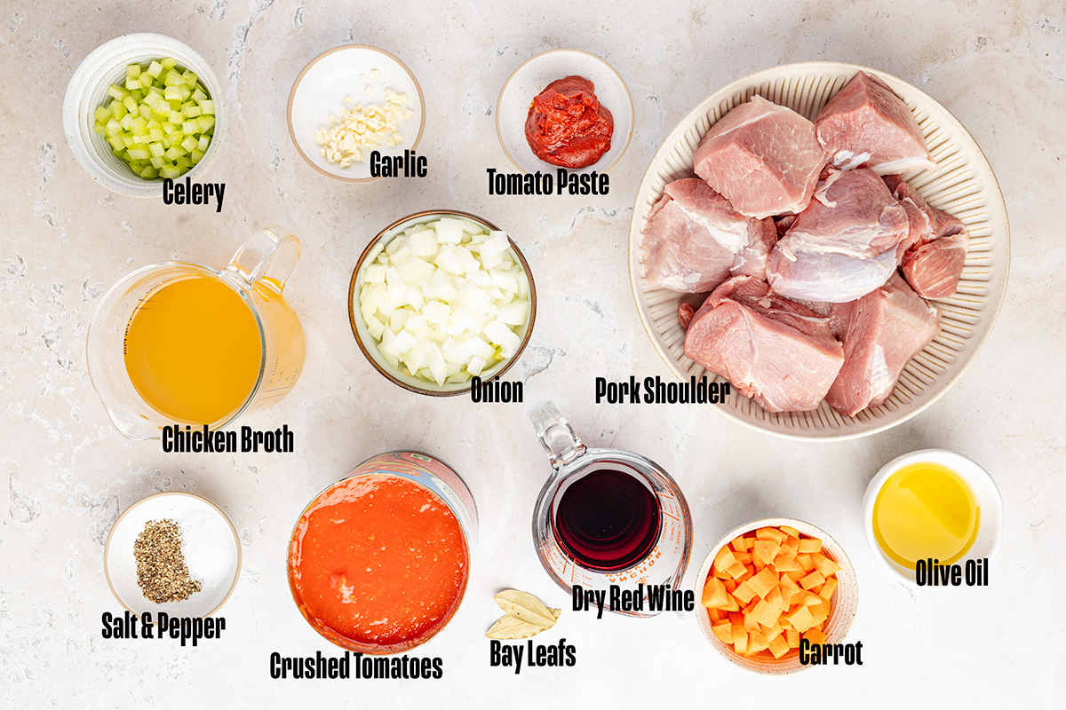 Ingredients to make this ragu with pork shoulder in bowls on a table.