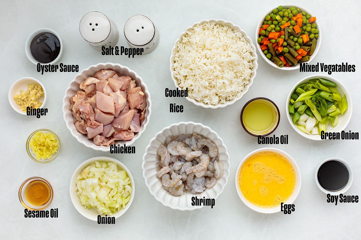 Ingredients to make this chicken and shrimp fried rice on a table.