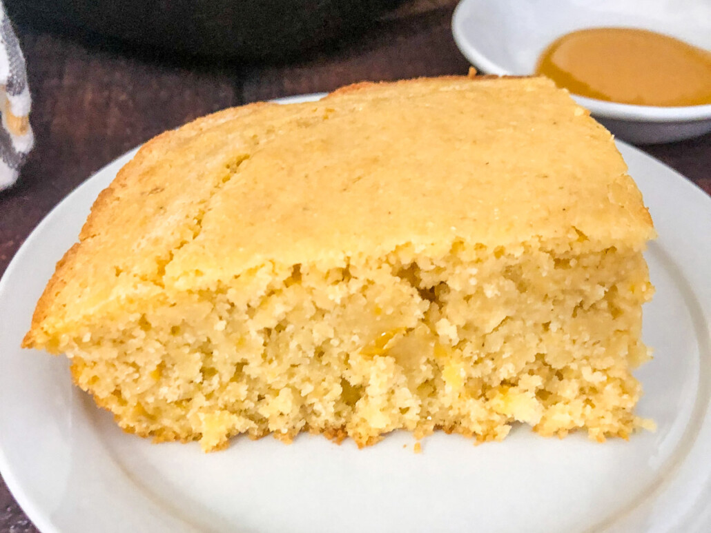 A slice of creamed corn cornbread on a plate to show the texture.