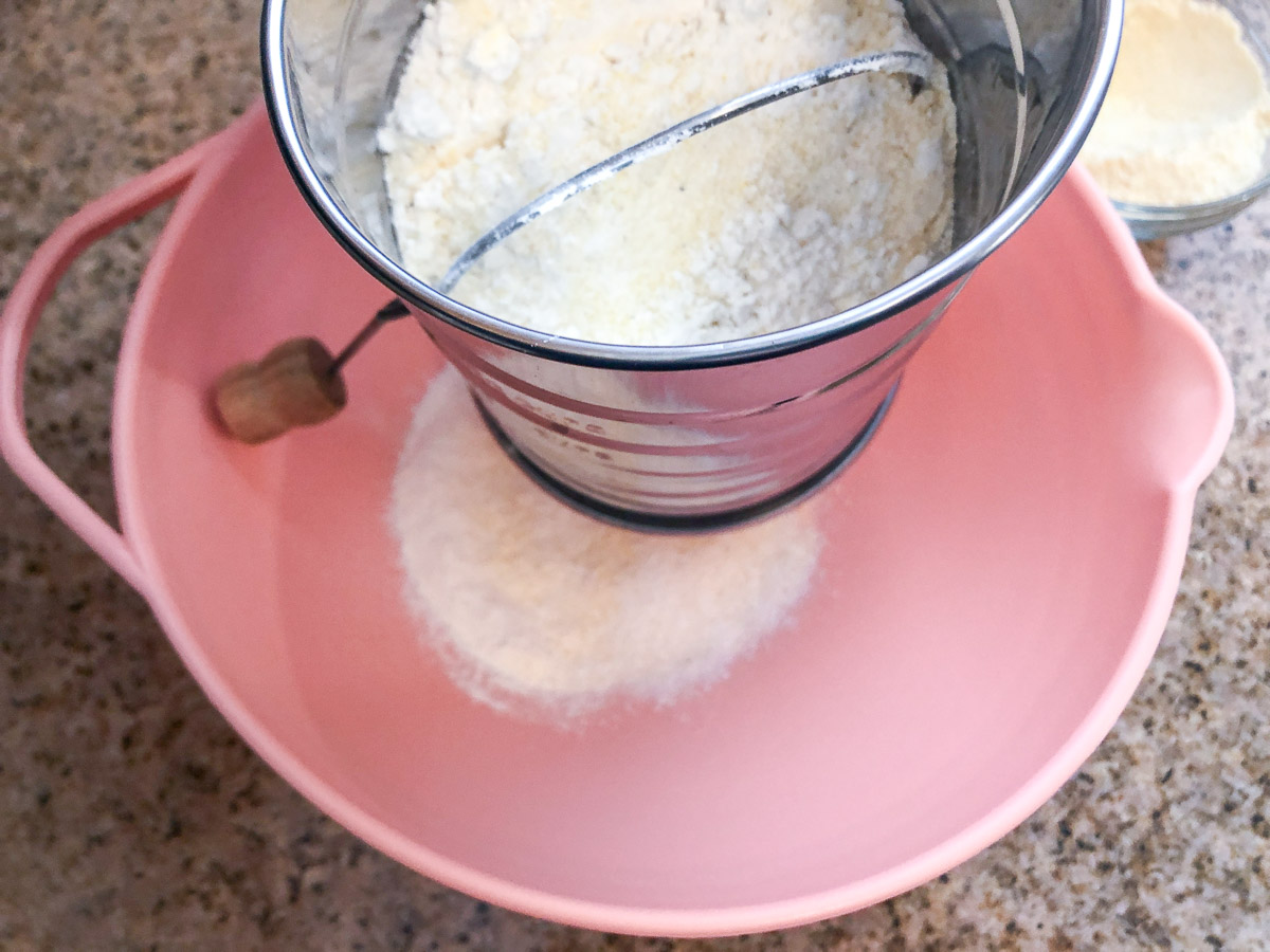 Sifting the dry ingredients into a mixing bowl.
