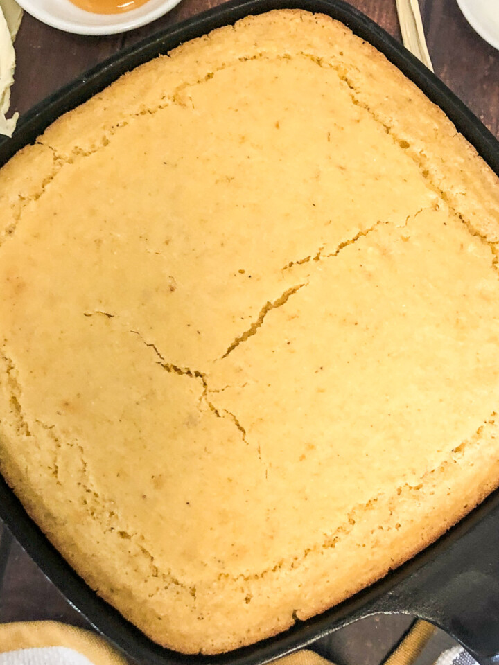 Creamed corn cornbread baked in a square cast iron skillet.