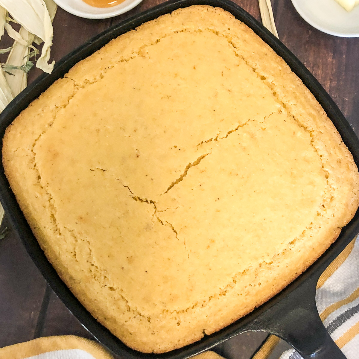 Creamed corn cornbread baked in a square cast iron skillet.
