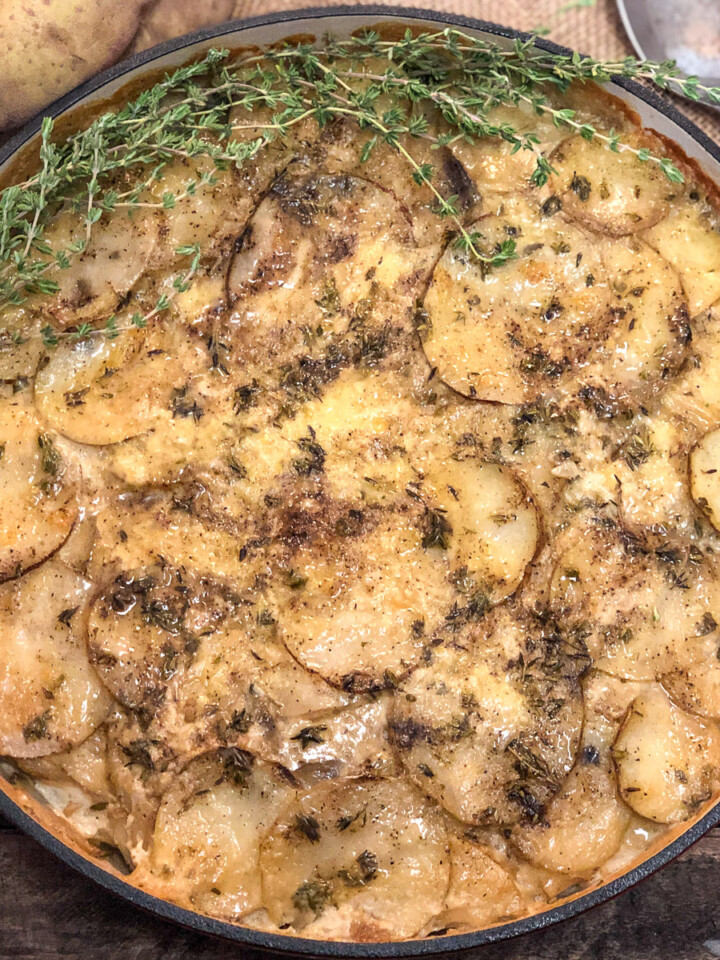 Skillet Scalloped Potato Gratin garnished with fresh thyme.