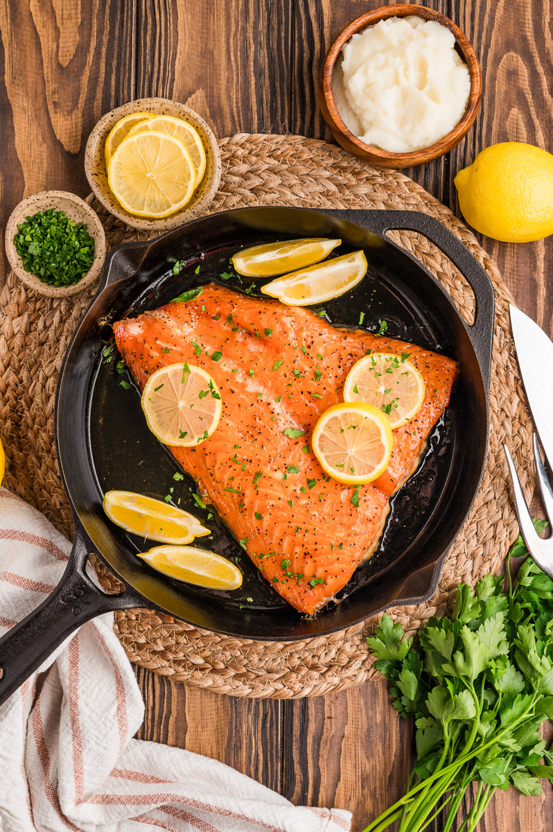 Salmon removed from the heat and lemon wedges added.