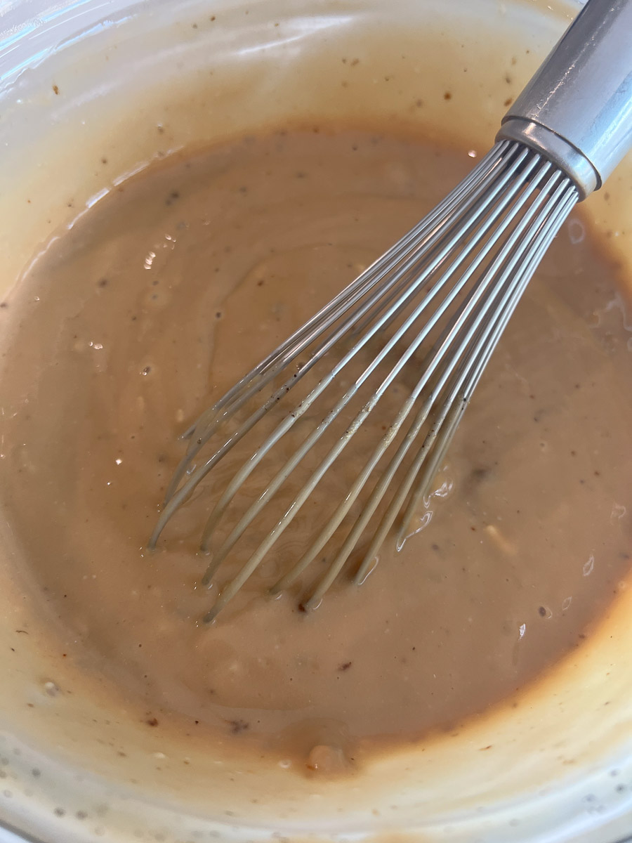 Soup mix, cream of mushroom soup, and whiskey mixed together in a bowl.