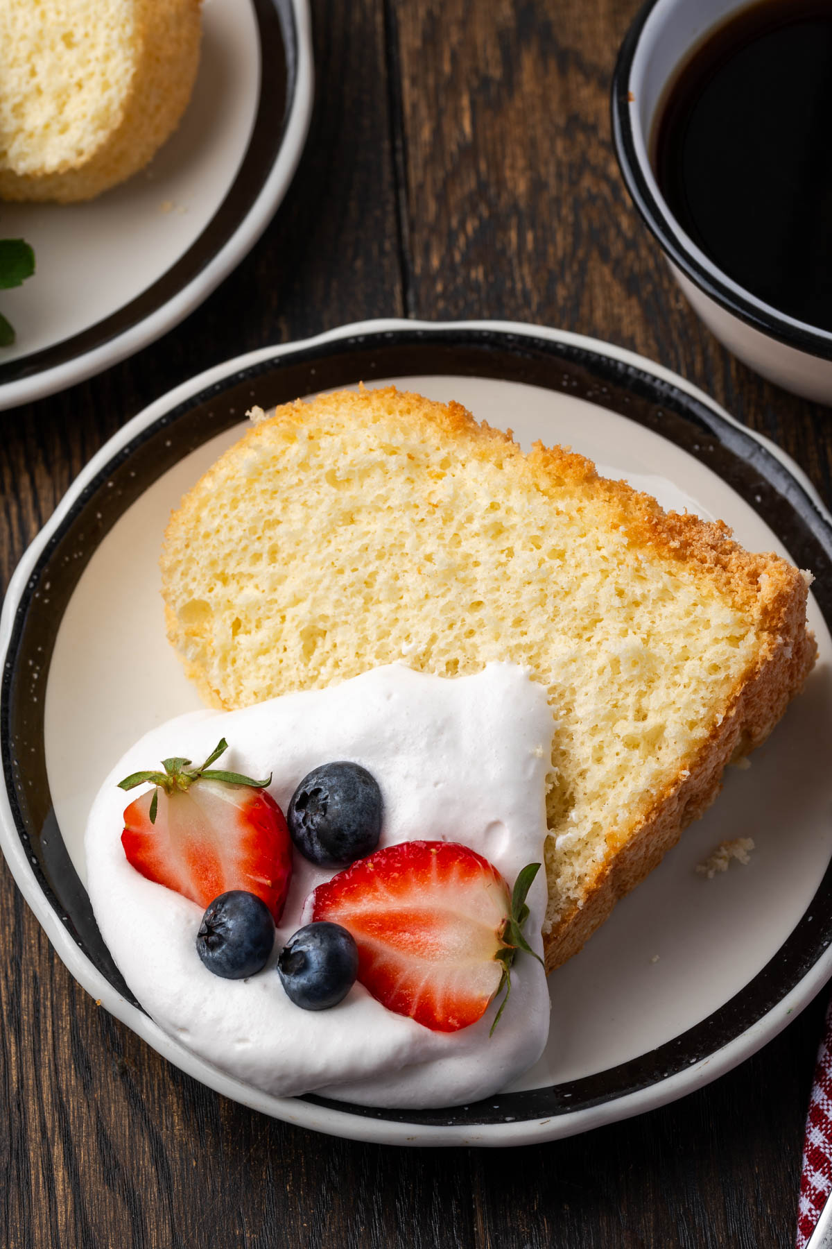 A slice of angel food cake with berries and whipped cream.
