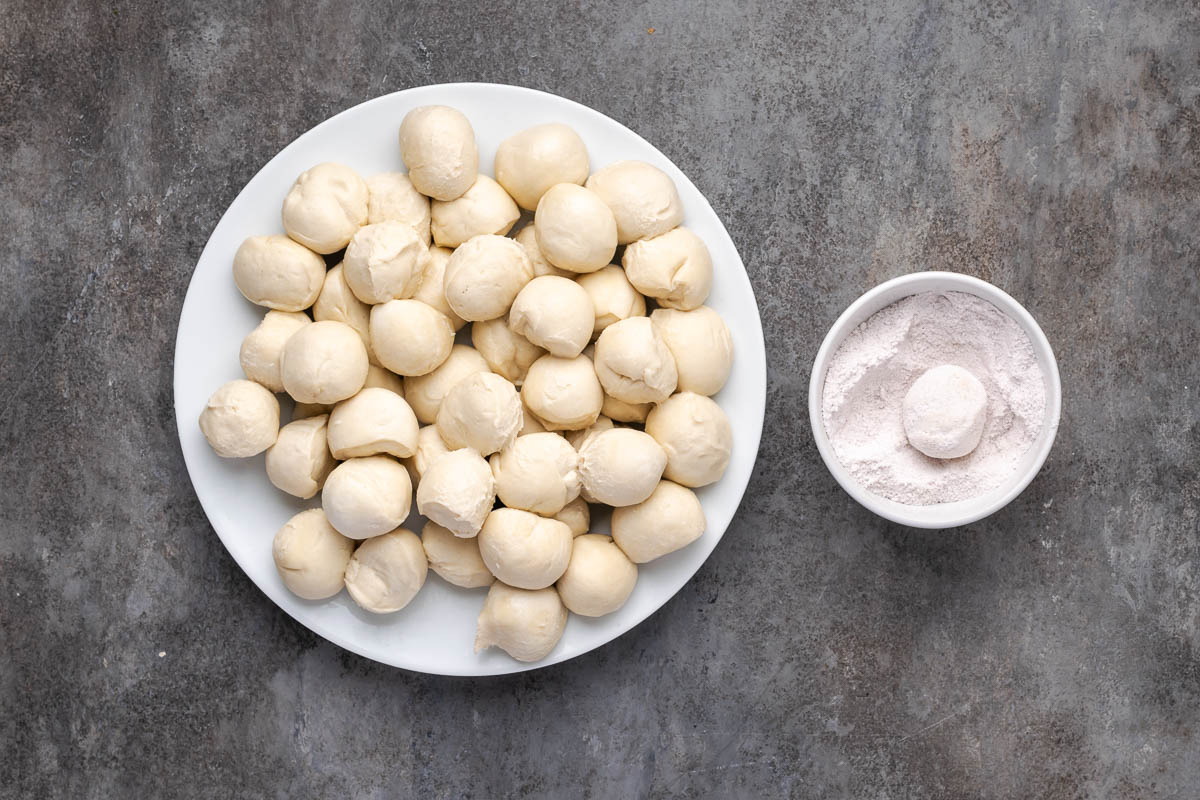 A plate of rhodes rolls and a bowl of butterscotch pudding.