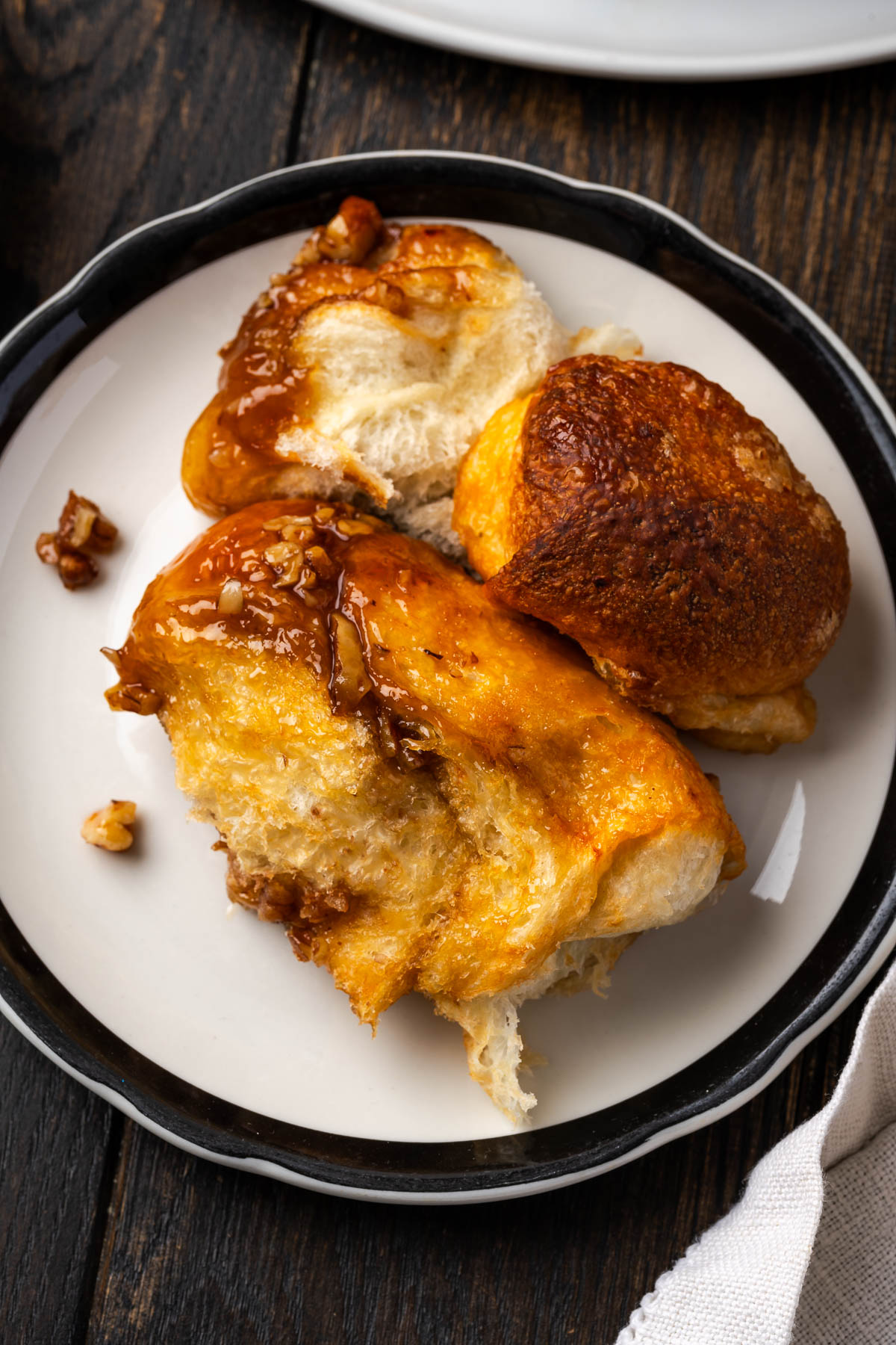 Pieces of monkey bread with butterscotch pudding on a plate.