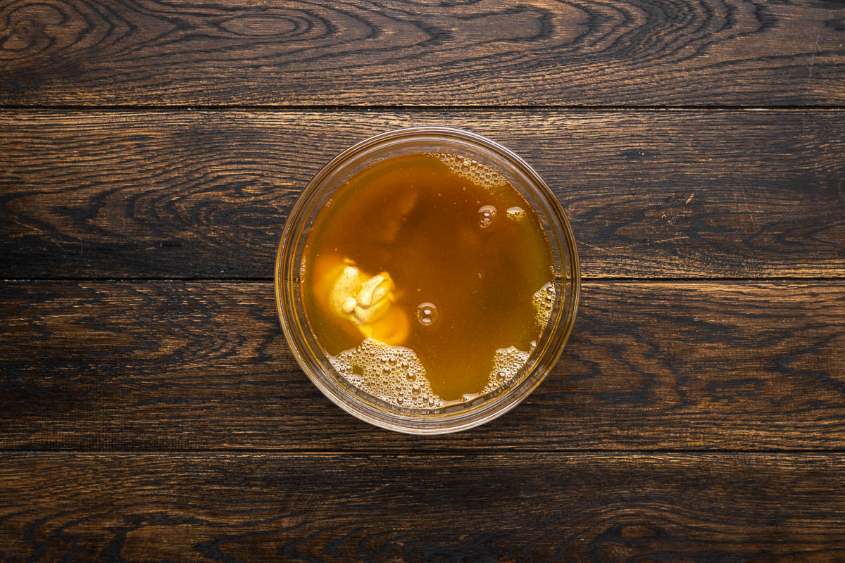 Brown sugar, honey, juice, and mustard in a bowl.