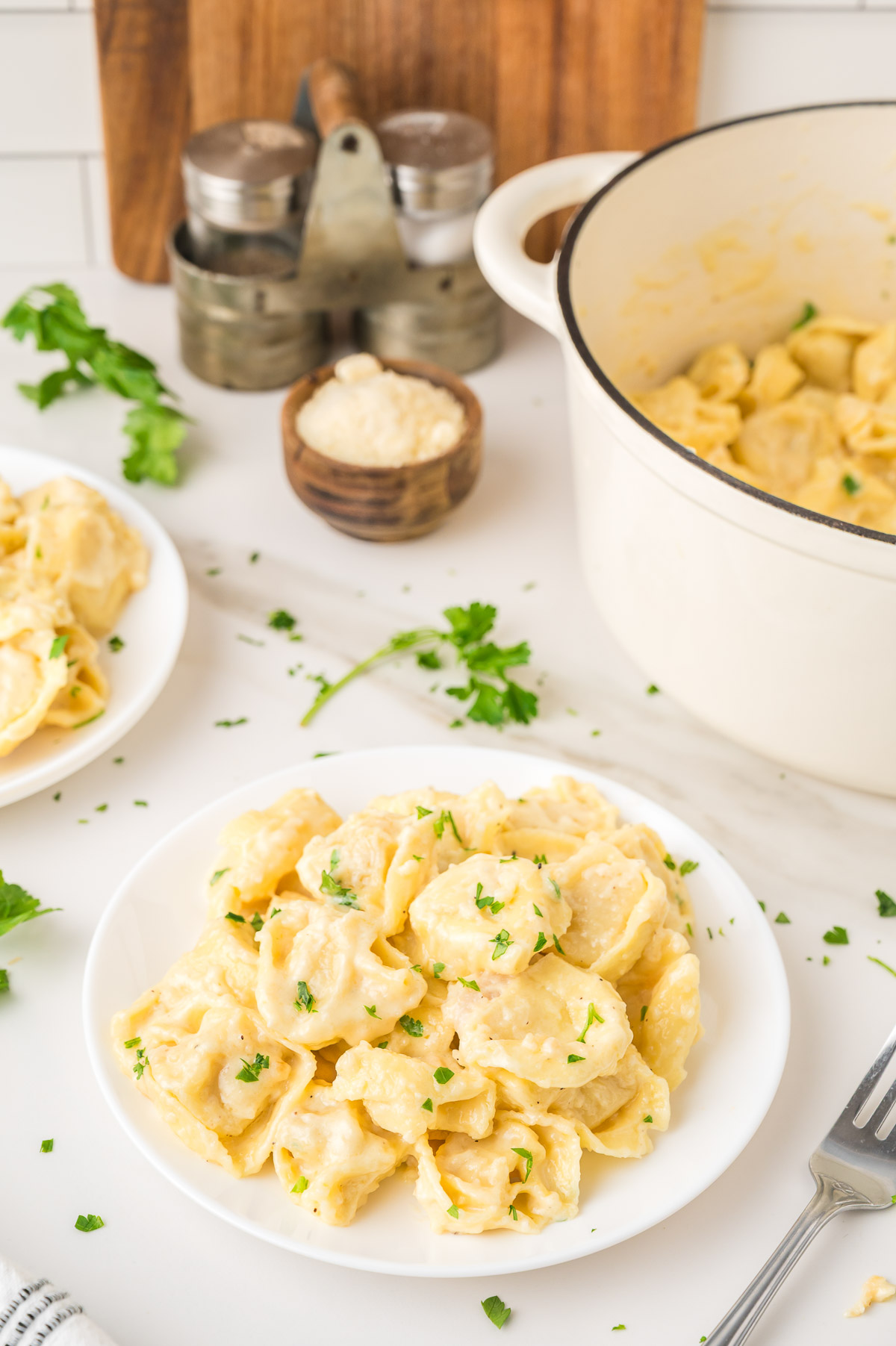 Creamy alfredo tortellini topped with fresh parsley in a bowl